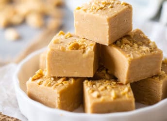 Peanut butter fudge cut into squares and arranged on a white plate.
