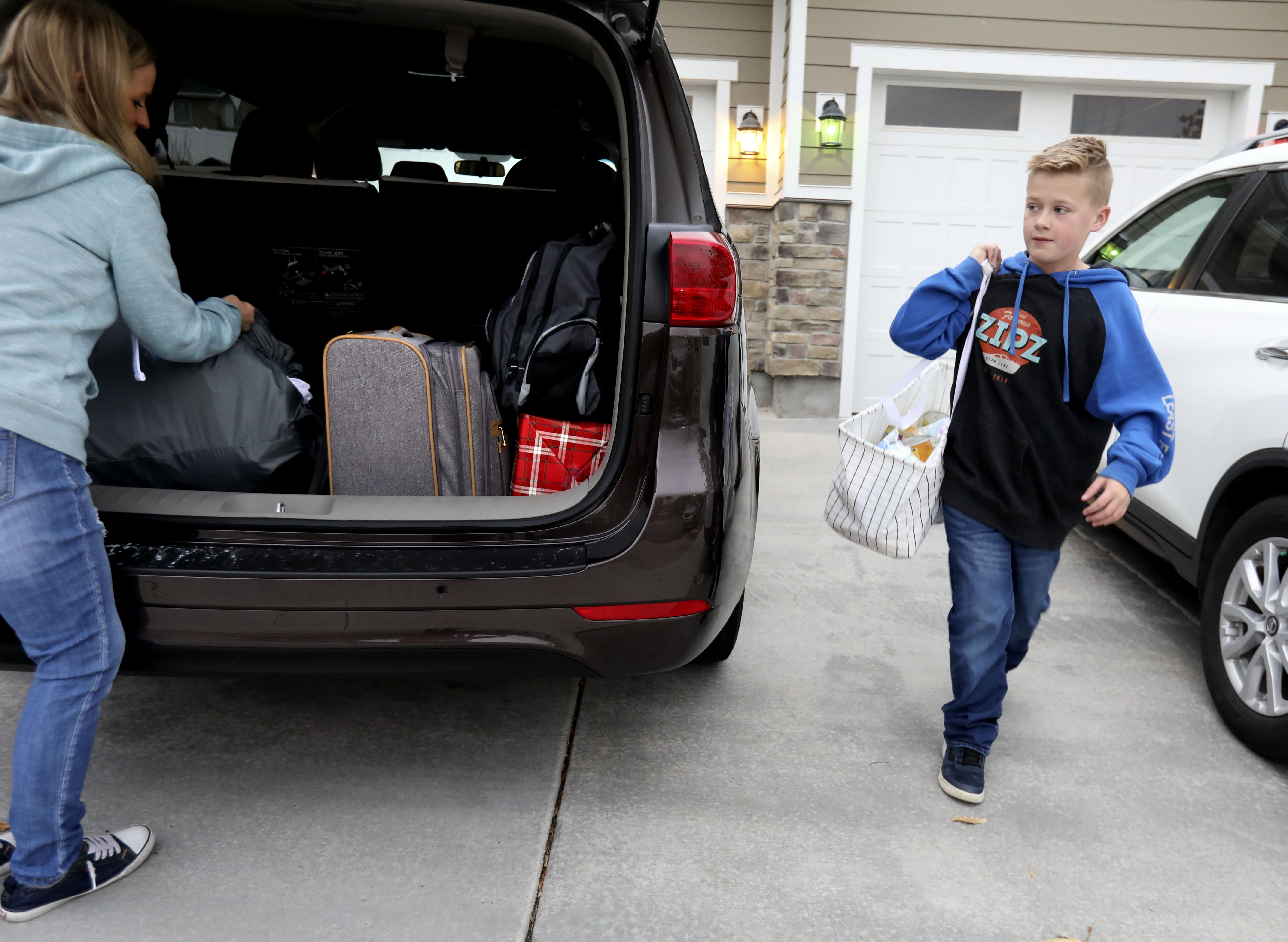 Bryce Spindle, 11, and his mother, Kendra, pack the car at their Herriman home before driving to Arizona on Friday, Nov. 22, 2019.