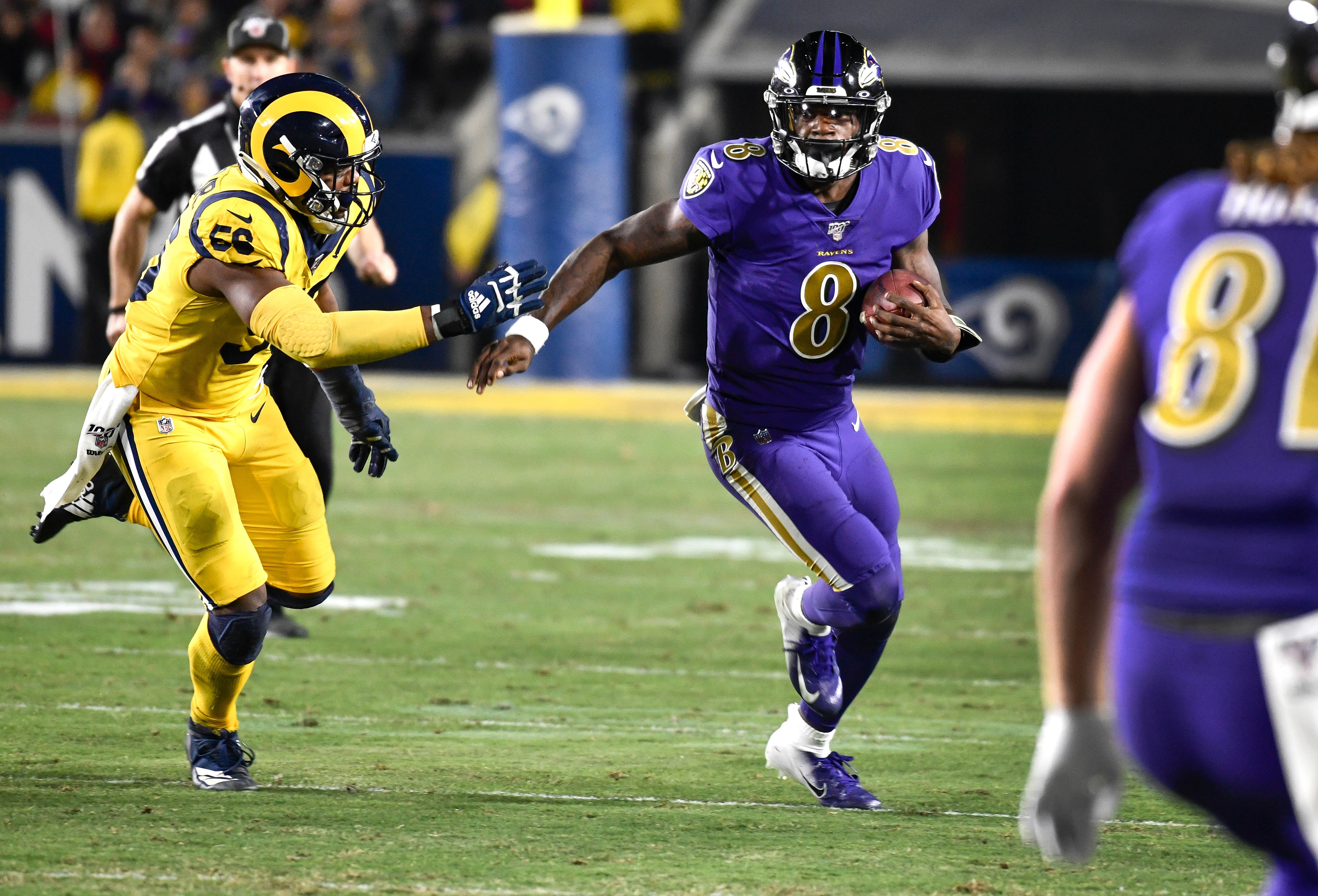 Baltimore Ravens quarterback Lamar Jackson tries to run past Los Angeles Rams defensive end Dante Fowler during the third quarter at Los Angeles Memorial Coliseum.