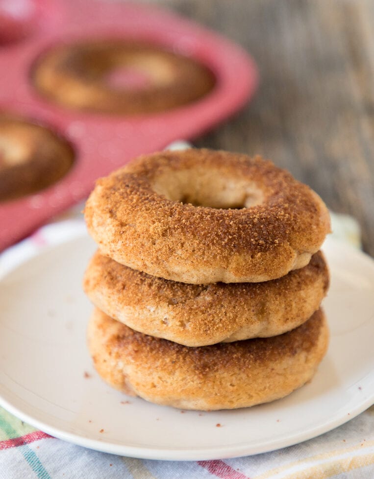 three baked apple cider donuts on a plate