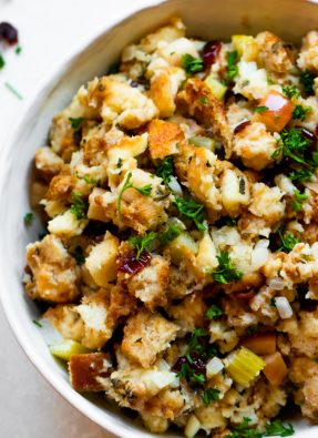 Close up of cranberry apple stuffing garnished with fresh parsley.