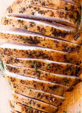 Sliced smoked turkey breast on a wood cutting board.