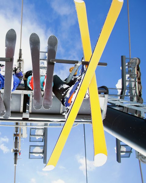 Fire personer med slalomski sitter i skiheis