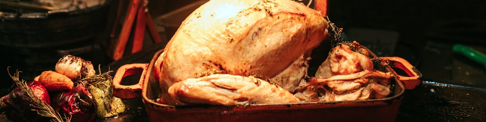 turkey in a roasting pan on a wood table