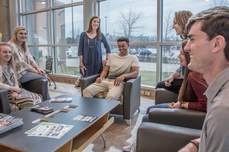 male student leaning out of a truck window with 'follow me to paducah, ky' bumper sticker on back window