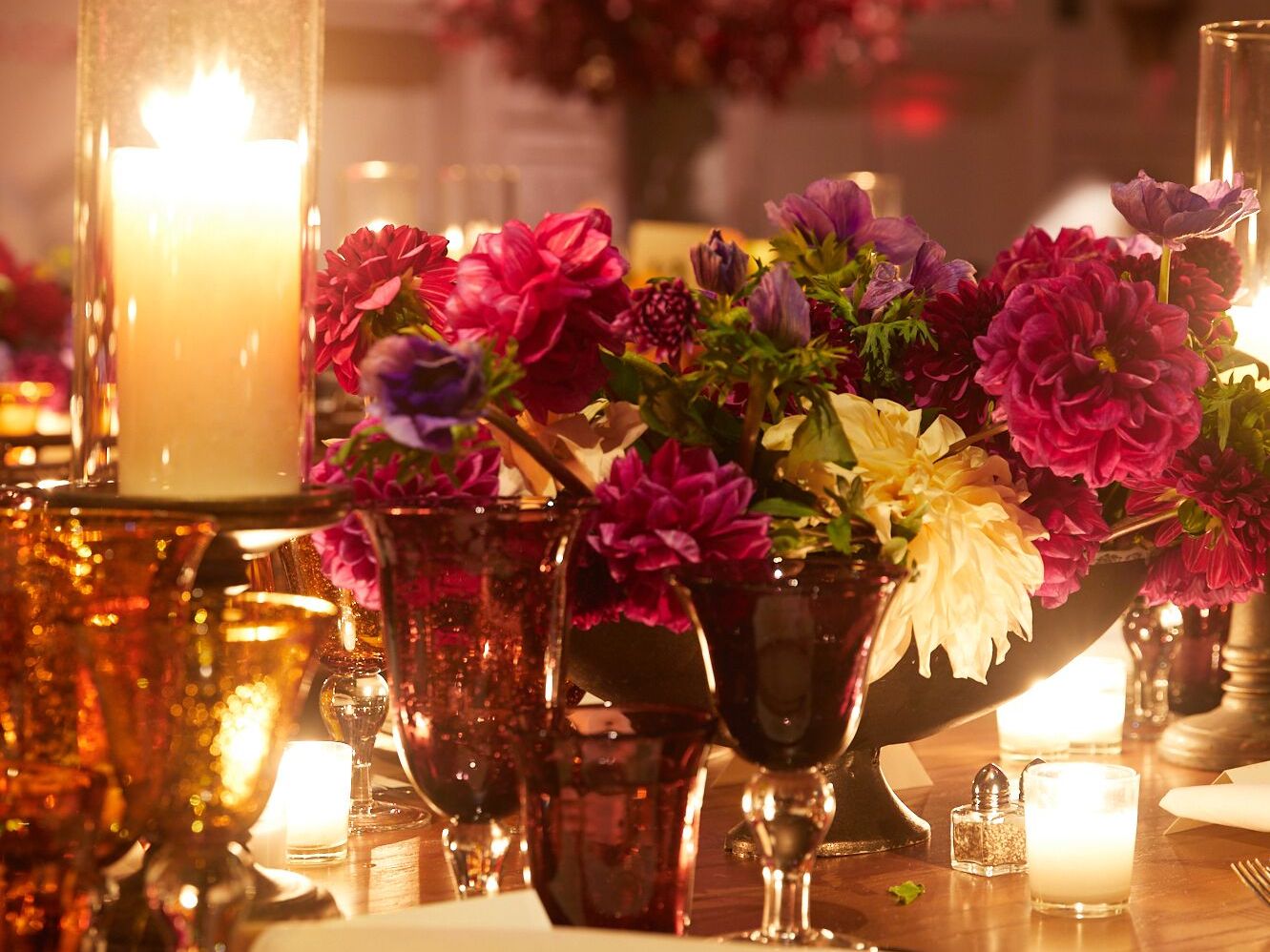 a bouquet of flowers on a table with candles
