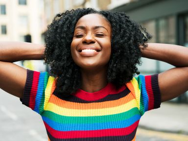 a curly haired woman smiling in the street