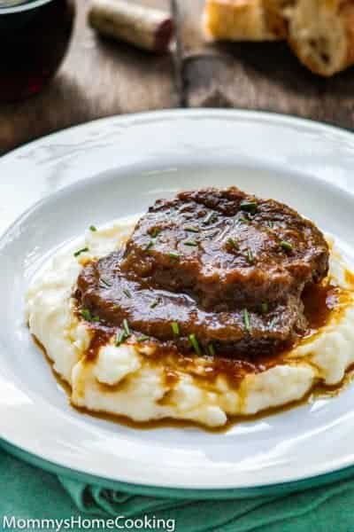 Venezuelan Asado Negro in a white plate with mashed potatoes