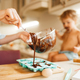 Mother and kid cooking and tastes melted chocolate