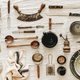 Kitchen utensils and tablewear over linen tablecloth, top view