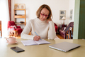 Middle age senior woman working at home using computer