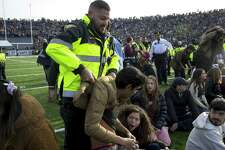An officer lifts a student up during a protest during halftime of the NCAA college football game between Harvard and Yale at the Yale Bowl in New Haven.