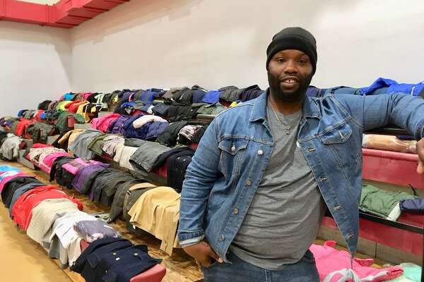 Harry Bell of Color a Positive Thought stands in front of the winter coats that will be given away Saturday in Bridgeport. Dec. 17, 2019
