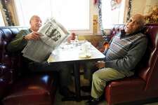 Bob Karp of Stamford, at left, folds up the Stamford Advocate newspaper as he listens to J. Ralph Murray of Stamford comments when interview about the Presidents Impeachment while having breakfast at Curley's diner in Stamford, Conn. on Dec. 19, 2019. Diners throughout the area, talked about the impeachment proceedings the day after an historic vote in the House, while being served eggs and bacon.