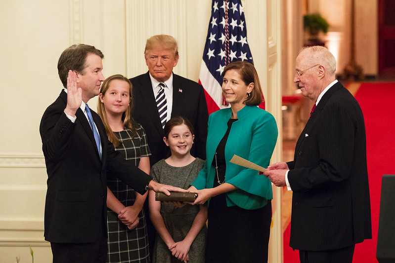 President Trump looks on as retired Supreme Court Justice Anthony Kennedy swears in Brett Kavanaugh to be the Supreme Court's 114th justice.