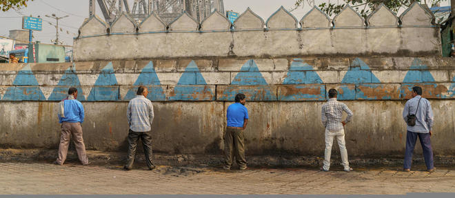 Des hommes urinent dans la rue &agrave; Calcutta.