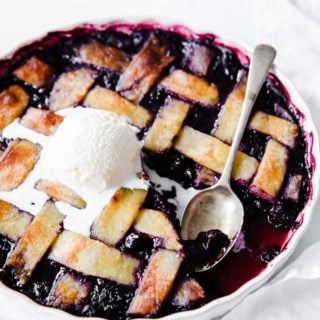 keto skinny mixed berry pie with a scoop of vanilla ice cream and a spoon