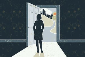 A woman stands in darkness at an open door