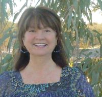 Ginny McMeans is a smiling brown haired brown eyed girl.