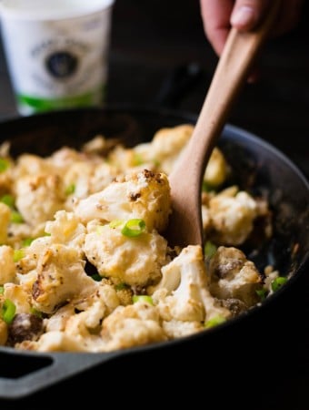 Close up photo of cauliflower gratin dish, ready to be plated with a wooden spoon
