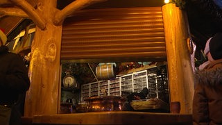 Eine Bude auf dem Bremer Weihnachtsmarkt fährt die Rollläden herunter.