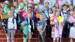 Erstklässler posieren bei ihrer Einschulung mit ihren Schlutüten.