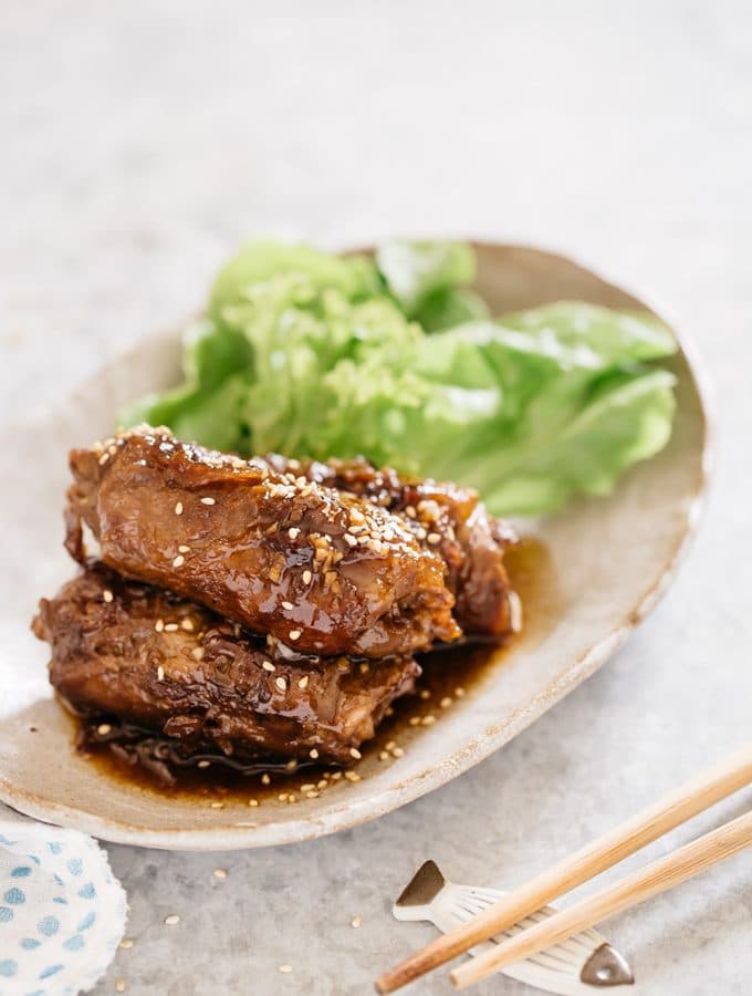 three Negimaki is served on an oval shaped plate with green salad