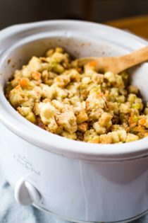 slow cooker stuffing in crockpot with wooden spoon