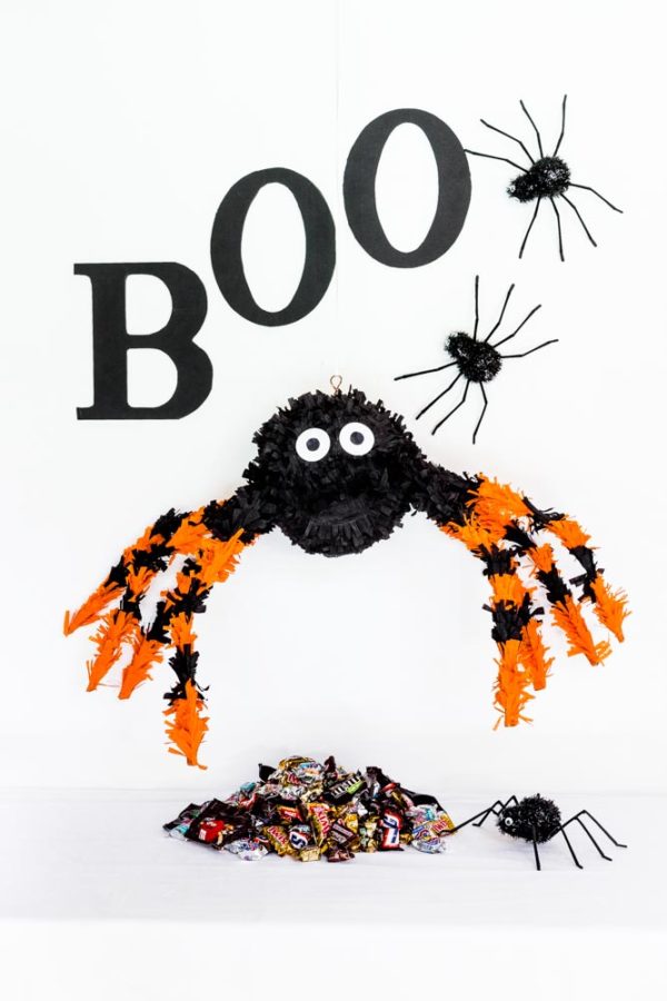 DIY Spider Pinata hanging above a pile of Halloween candy.