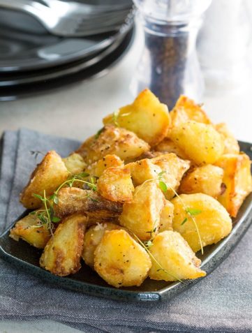 A dish piled high with golden, Crispy Roast Potatoes