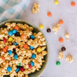 Peanut Butter Popcorn in a bowl surrounded by a blue gingham napkin