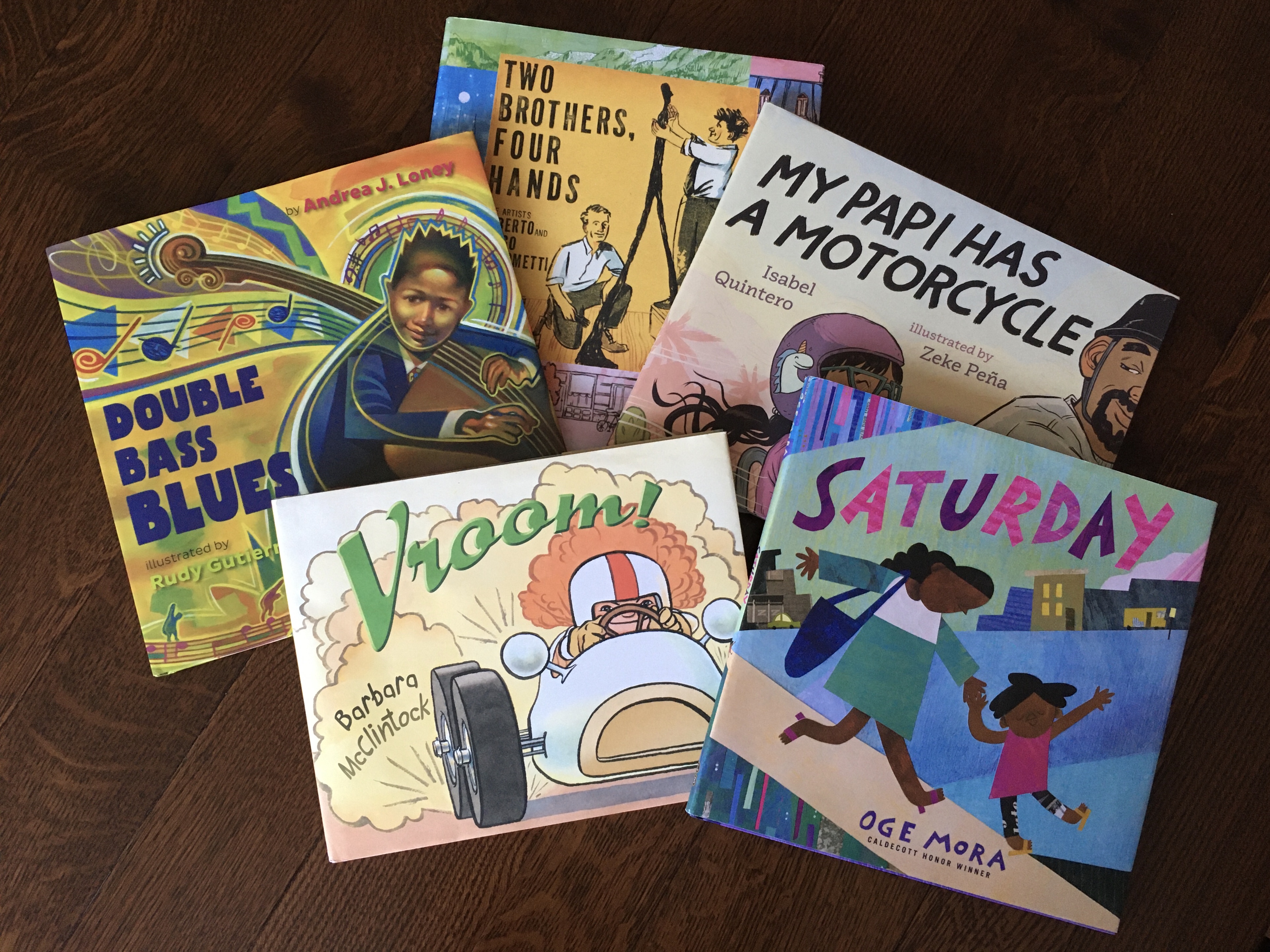 Image of five books laid out on a table -- Double Bass Blues; My Papi Has a Motorcycle; Saturday; Two Brothers, Four Hands; and Vroom!