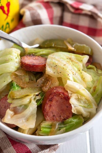 Bowl of kielbasa and cabbage sprinkled with creole spice