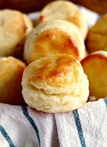 gluten-free biscuits in a basket with a white and blue kitchen towel