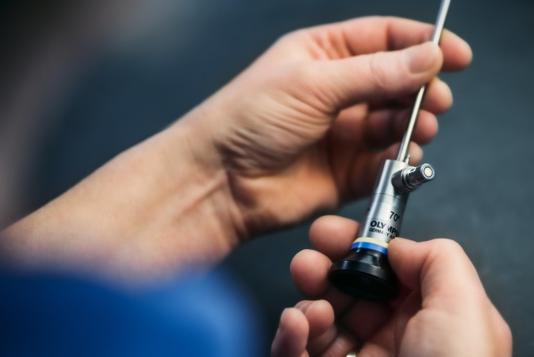 Welcome to Olympus: a technican holds a part of a medical device at Olympus Surgical Technologies Europe