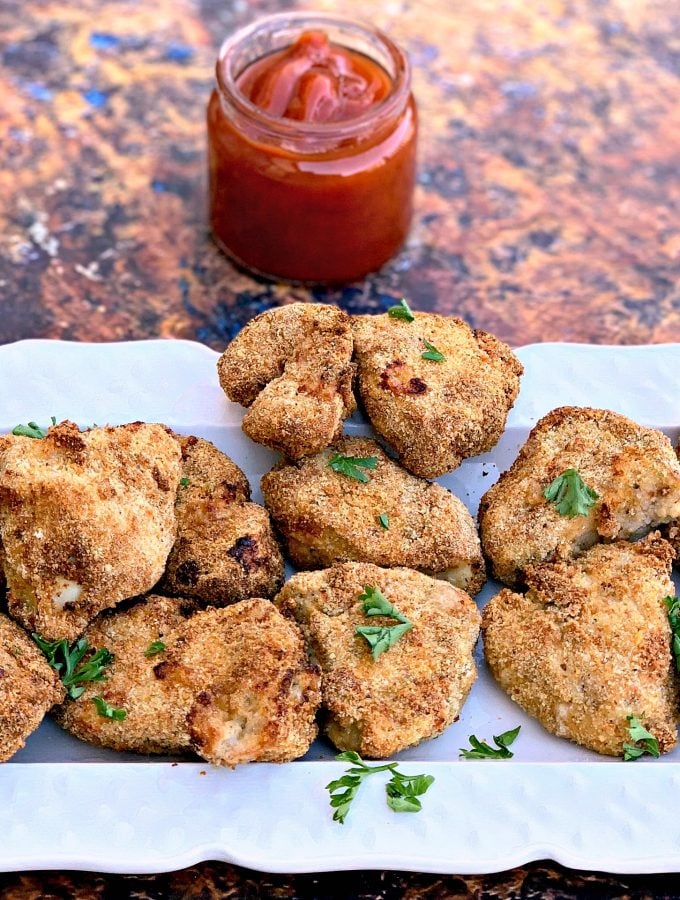 air fryer chicken nuggets on a white plate with ketchup