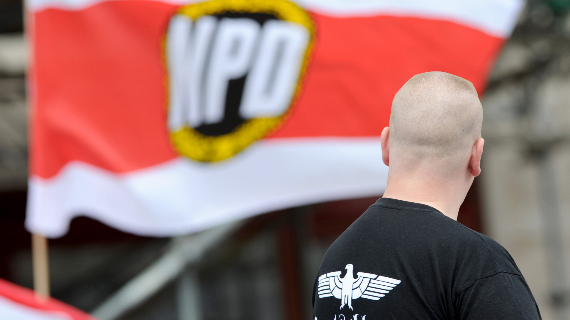 Ein Unterstützer der NPD steht bei einer NPD-Kundgebung am Strausberger Platz in Berlin.