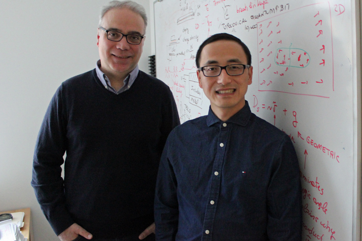 Enrico Rossi and Xiang Hu stand in front of a whiteboard