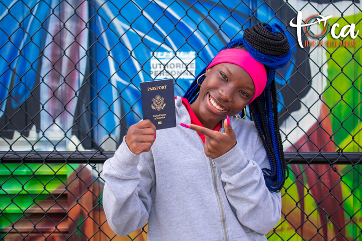 A student holds and points to a U.S. passport